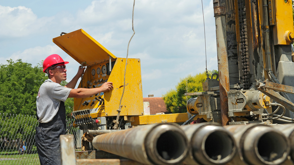 Oil rig machine operator using control panel to manage emergency shutdown and safety systems.