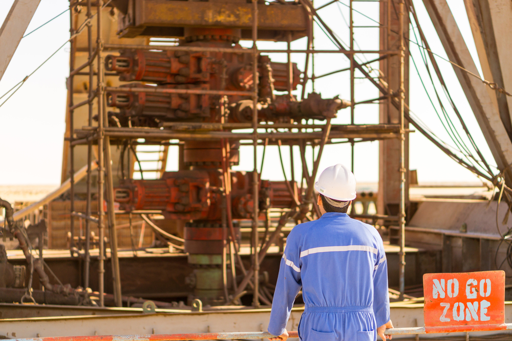 AnEngineerCheckTheBlowoutPreventerStack Engineer inspecting a blowout preventer (BOP) stack during maintenance and safety checks at an oil and gas drilling site.